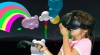 Fillette jouant à A-Painter avec un casque et des manettes de réalité virtuelle