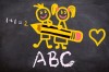 Dessin sur tableau noir d’une fille et d’au garçon tenant devant eux un gros crayon ayant écrit 1 + 1 = 2 et un cœur à droite et « ABC » à la craie blanche en dessous (stux, back to school, Pixabay)